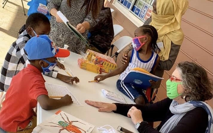 Black children working on art projects with older women