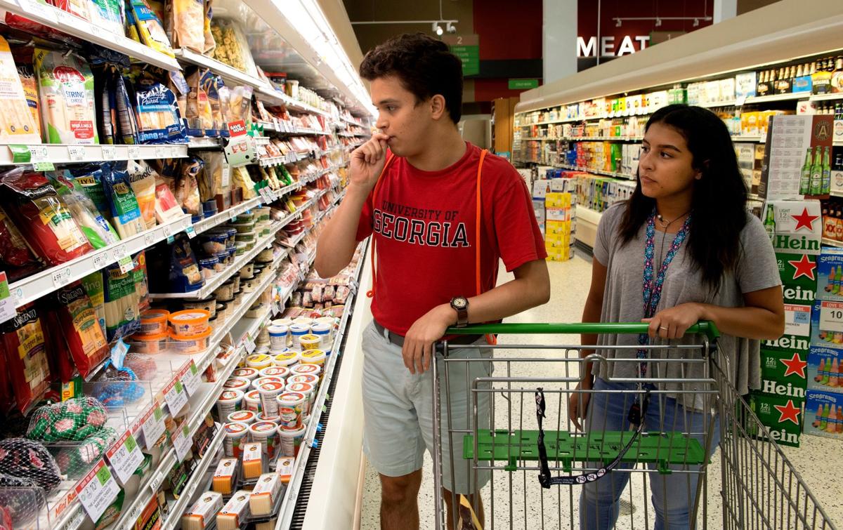 Eric Ruiz shops for cheese at a nearby Publix with Sofia Morales, a direct support professional who takes him into the community every week and helps him navigate society.