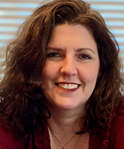 headshot of Rena Harris, a white woman with long wavy dark brown hair smiles at the camera