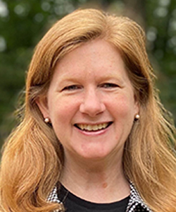 headshot of Lisa Newbern, a white woman with long reddish hair smiles at the camera