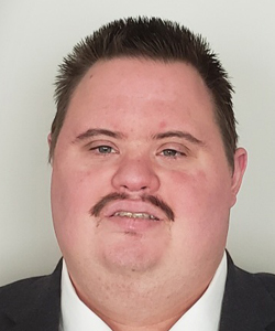 headshot of Wesley Ford, a young white man with short black hair and a mustache looks at the camera